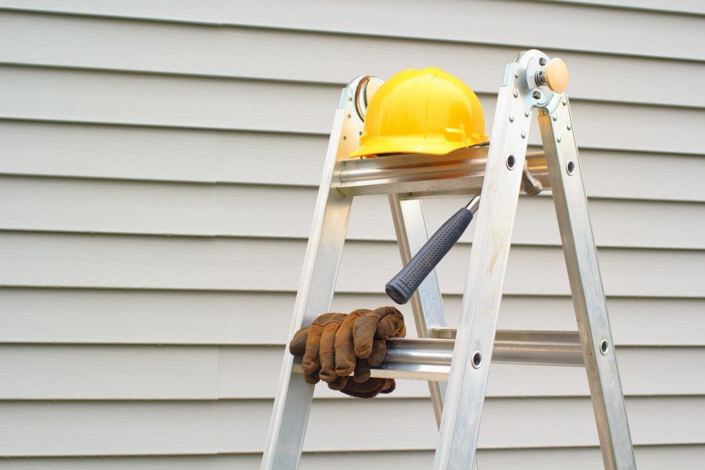 ladder and safety gear beside house's exterior