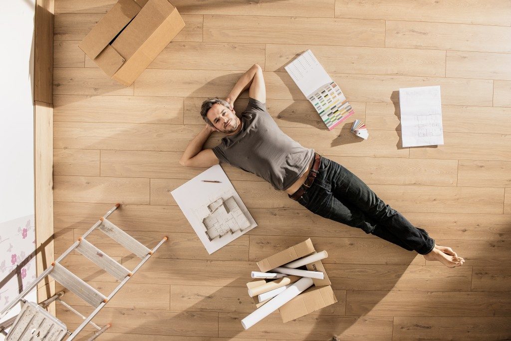 man laying on the floor planning renovation