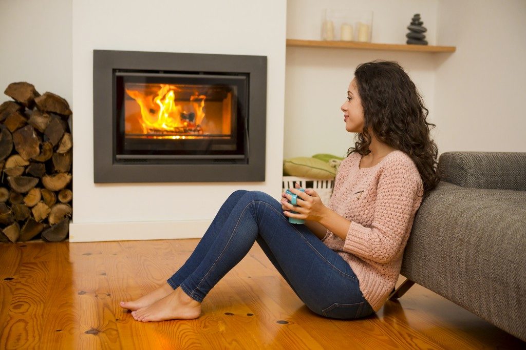 Woman sitting beside the fireplace