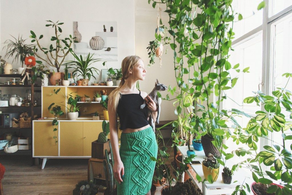 woman in her apartment surrounded by plants