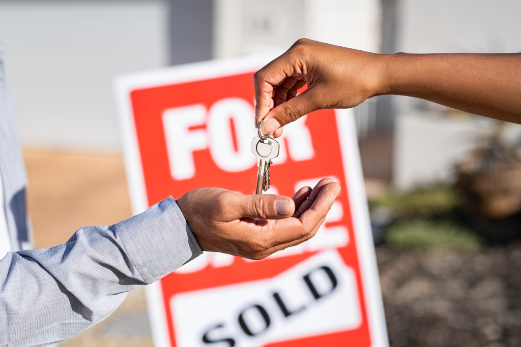 saleswoman or real estate agent giving home keys to new property owner