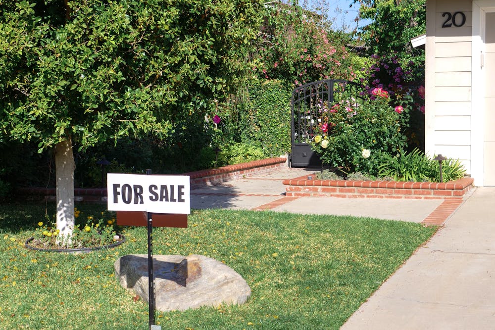 a for sale sign in front of a house